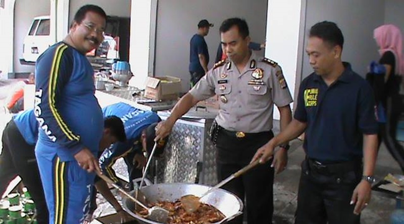 Tampak Kapolres AKBP Muhammad Suhanda SIK ikut menggoreng ikan bagi para korban banjir